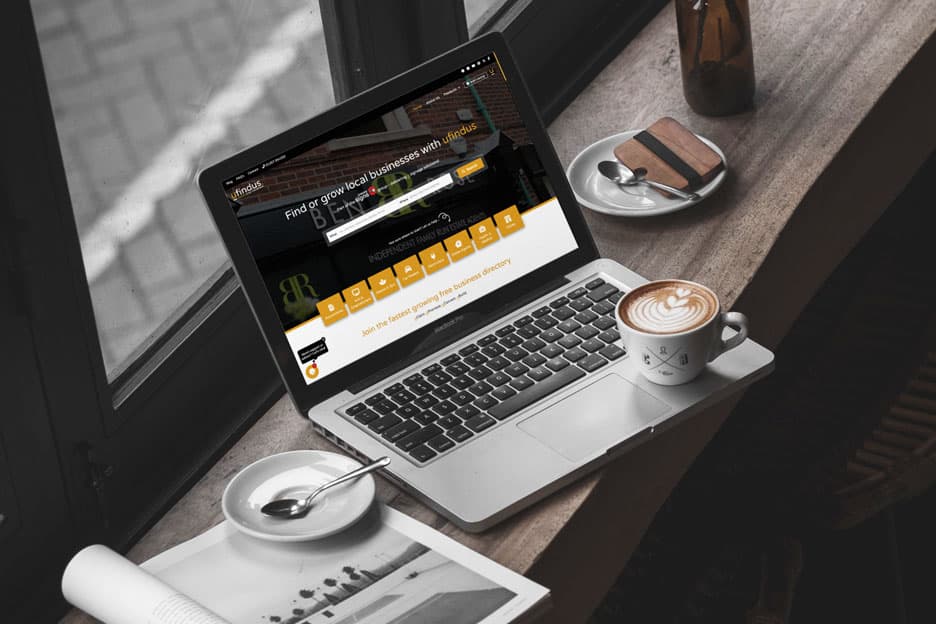 Customer finding business on laptop in coffee shop